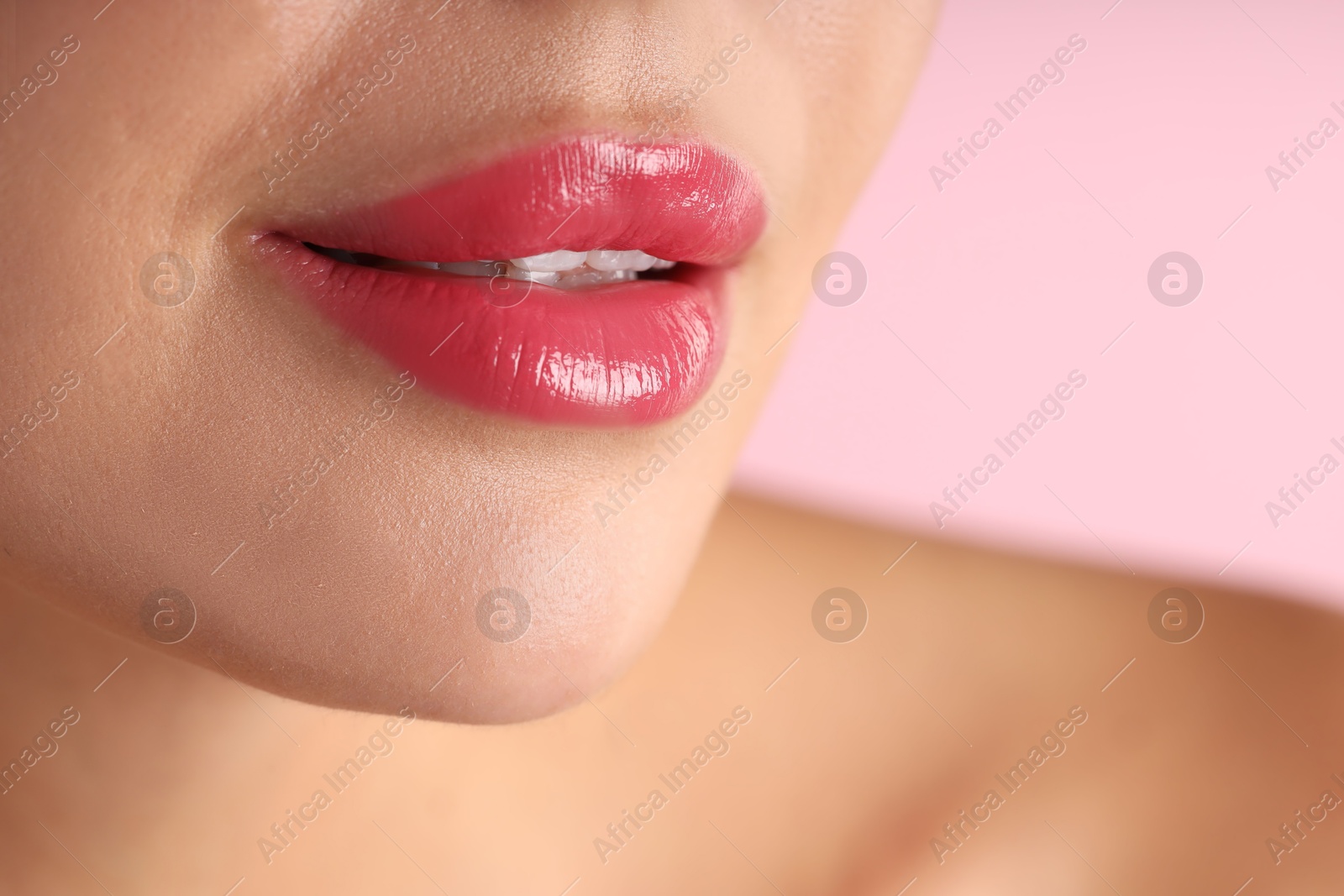 Photo of Woman with beautiful lipstick on her lips against pink background, macro view