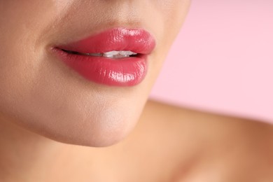 Photo of Woman with beautiful lipstick on her lips against pink background, macro view