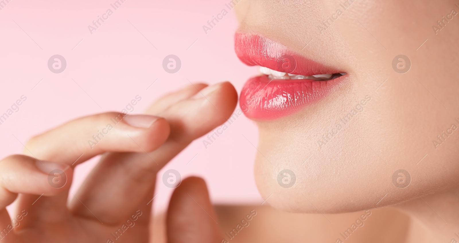 Photo of Woman with beautiful lipstick on her lips against pink background, macro view