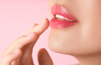 Photo of Woman with beautiful lipstick on her lips against pink background, macro view