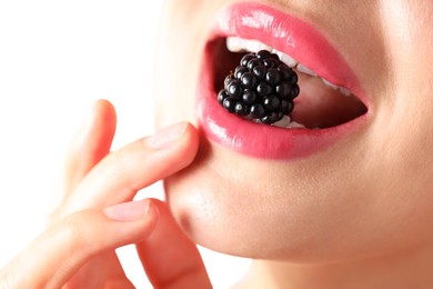 Photo of Woman with beautiful pink lipstick on her lips and blackberry against white background, macro view
