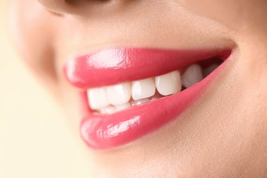 Photo of Woman with beautiful pink lipstick on her lips against beige background, macro view