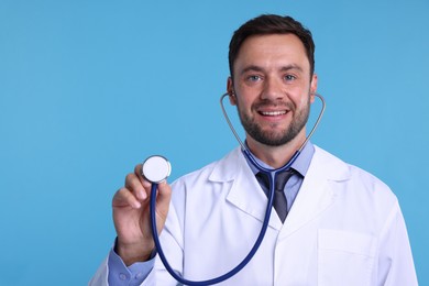 Photo of Pediatrician with stethoscope on light blue background