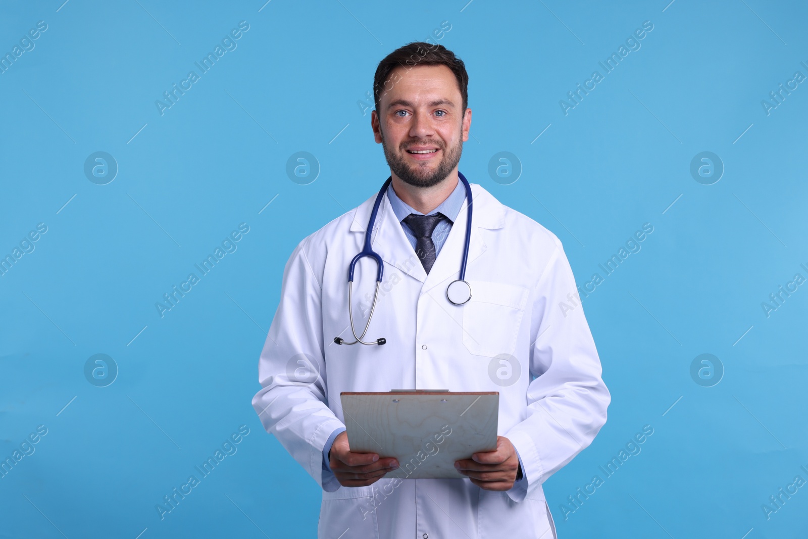 Photo of Pediatrician with stethoscope and clipboard on light blue background