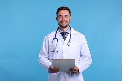 Photo of Pediatrician with stethoscope and clipboard on light blue background