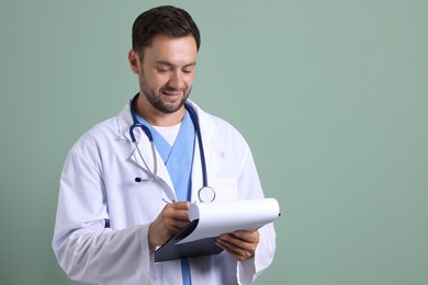 Photo of Pediatrician with clipboard writing notes on green background. Space for text