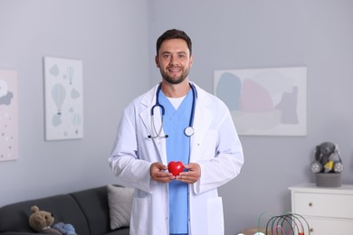 Photo of Professional pediatrician with heart model in hospital