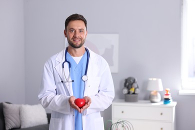 Photo of Professional pediatrician with heart model in hospital