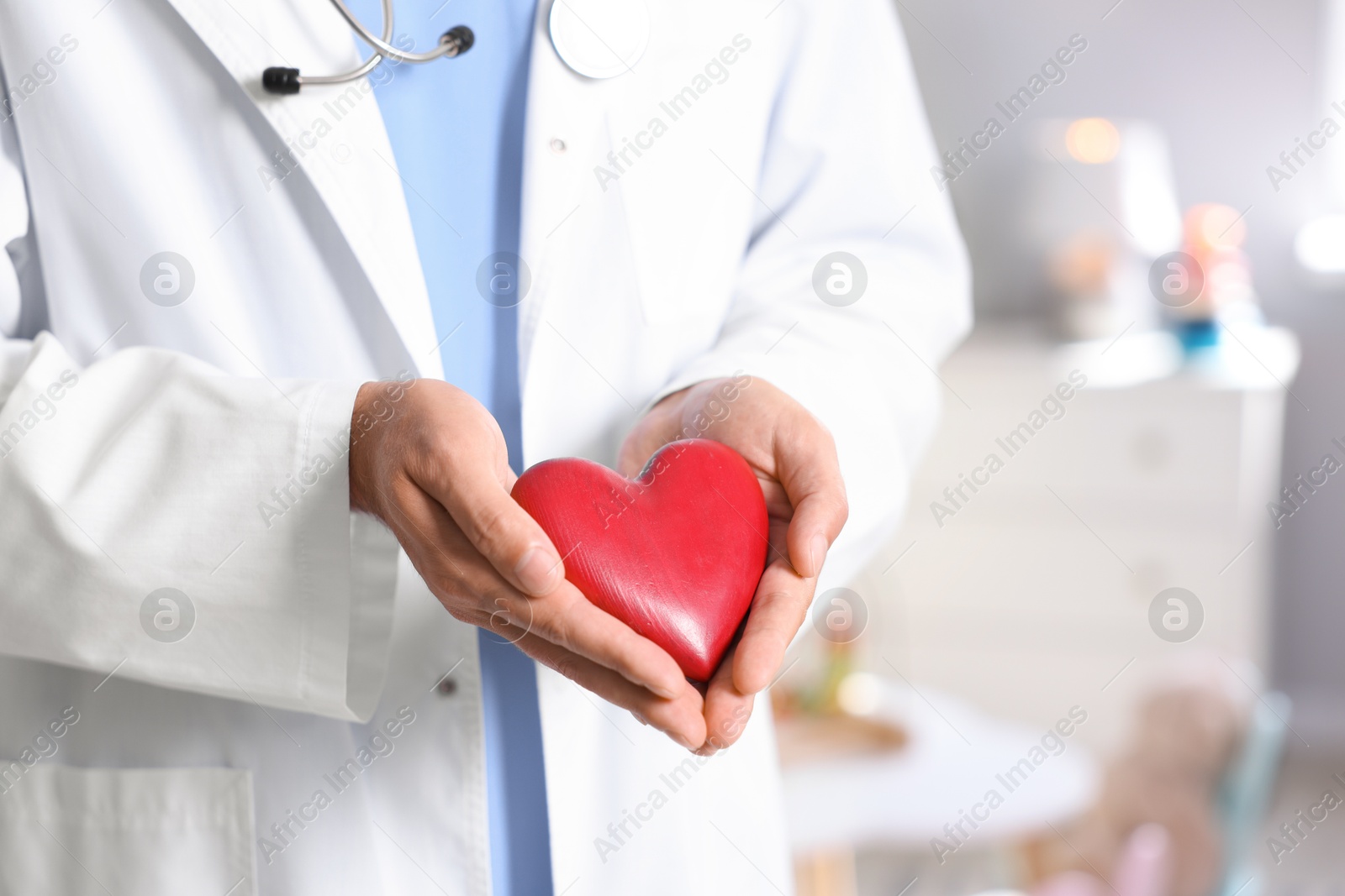 Photo of Pediatrician with heart model in hospital, closeup