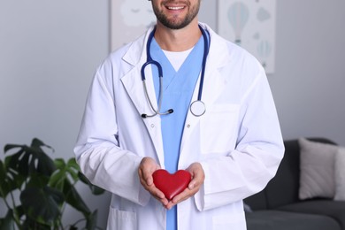 Photo of Pediatrician with heart model in hospital, closeup