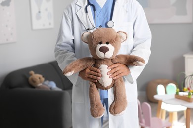 Photo of Pediatrician with teddy bear in hospital, closeup