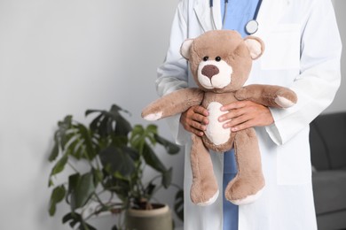 Photo of Pediatrician with teddy bear in hospital, closeup. Space for text
