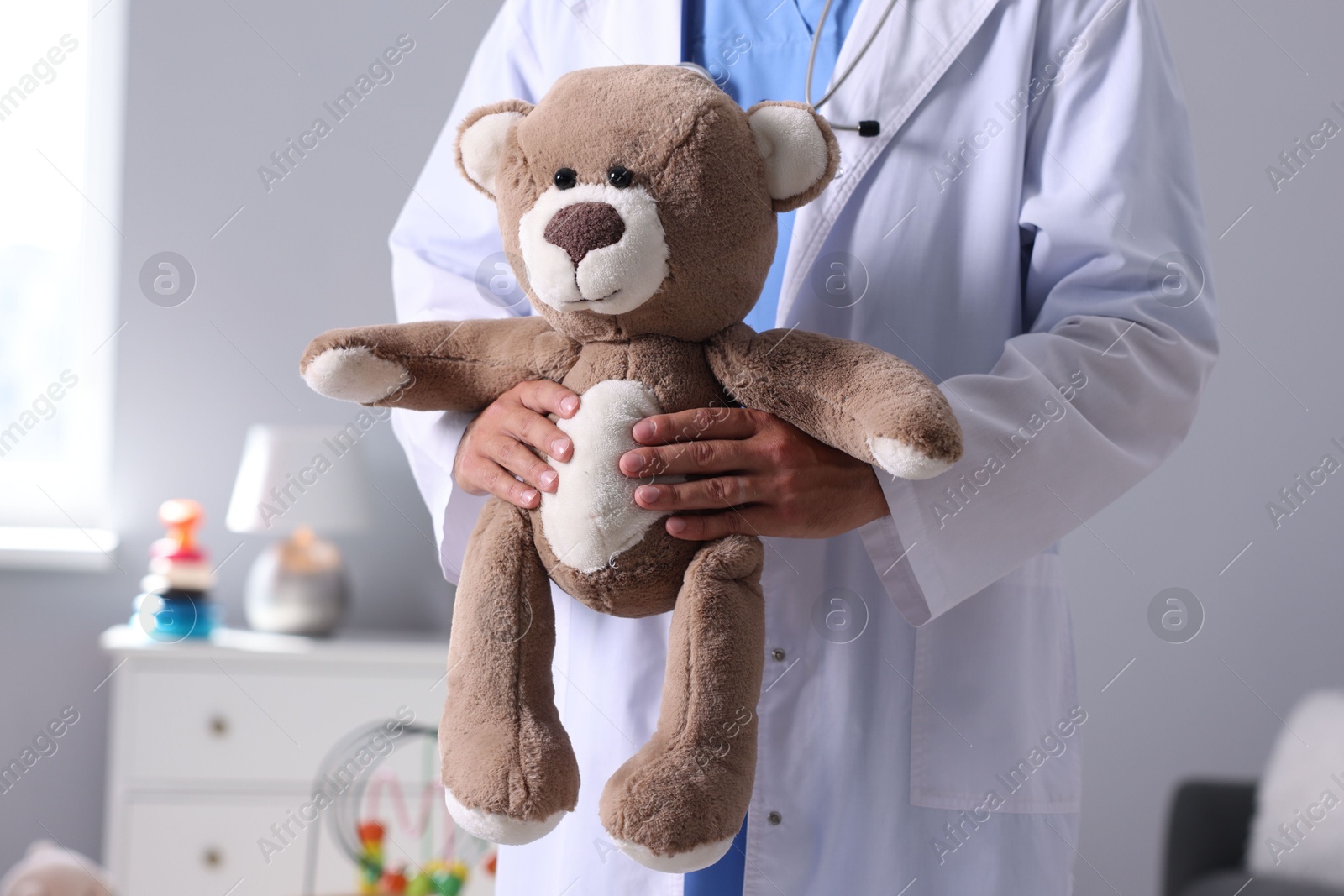 Photo of Pediatrician with teddy bear in hospital, closeup