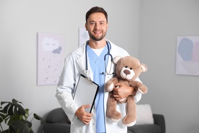 Photo of Pediatrician with teddy bear and clipboard in hospital