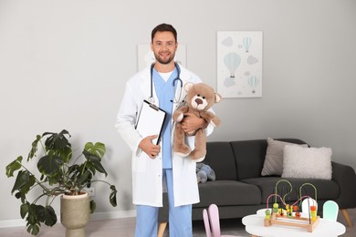 Photo of Pediatrician with teddy bear and clipboard in hospital