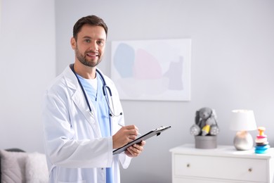 Photo of Pediatrician with clipboard writing notes in hospital. Space for text
