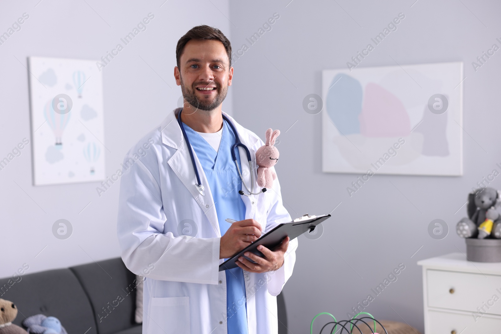 Pediatrician with clipboard writing notes in hospital. Space for text Photo of Pediatrician with clipboard writing notes in hospital. Space for text