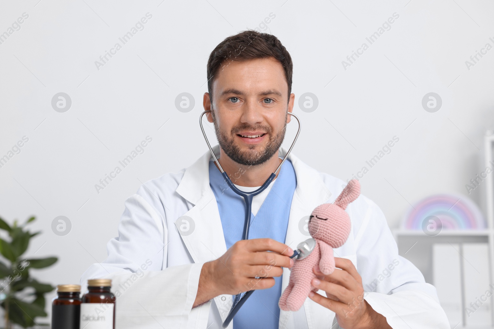 Photo of Pediatrician checking heartbeat of toy bunny in hospital