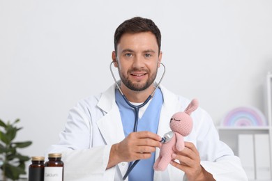 Photo of Pediatrician checking heartbeat of toy bunny in hospital