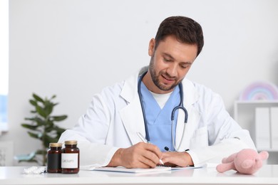 Photo of Professional pediatrician working at desk in hospital