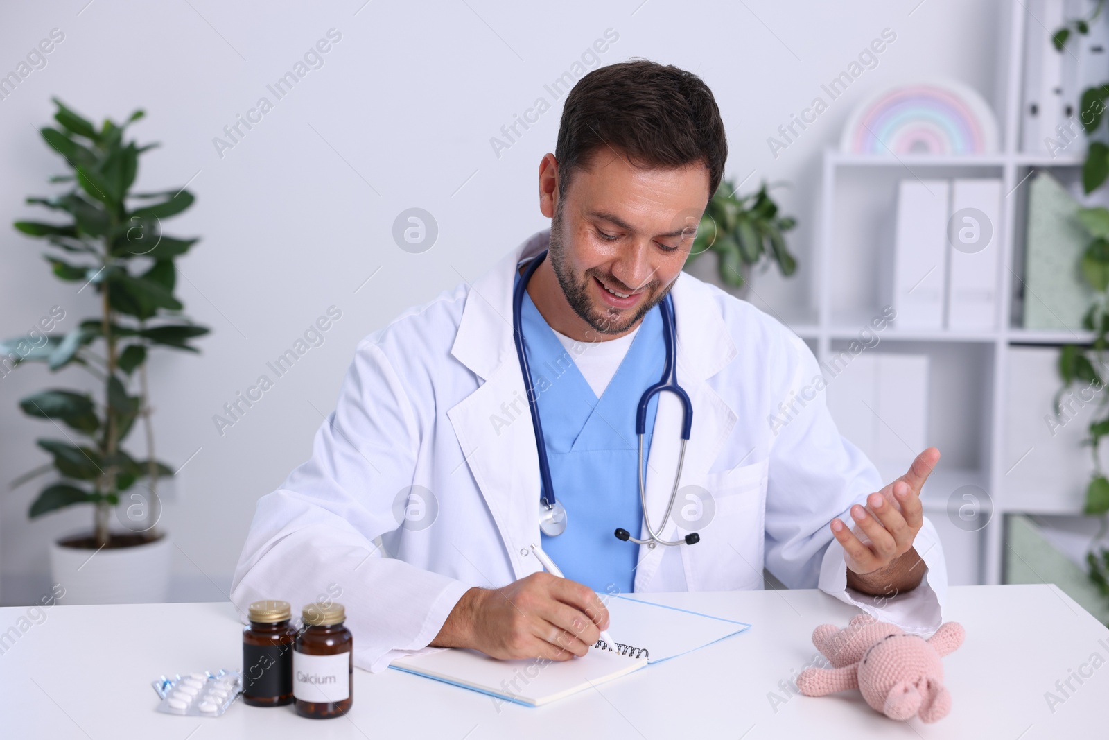 Photo of Professional pediatrician working at desk in hospital