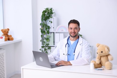 Photo of Pediatrician with laptop at desk in hospital