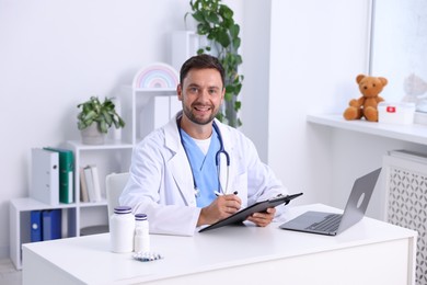 Photo of Professional pediatrician working at desk in hospital