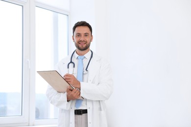 Photo of Pediatrician with stethoscope and clipboard in hospital. Space for text