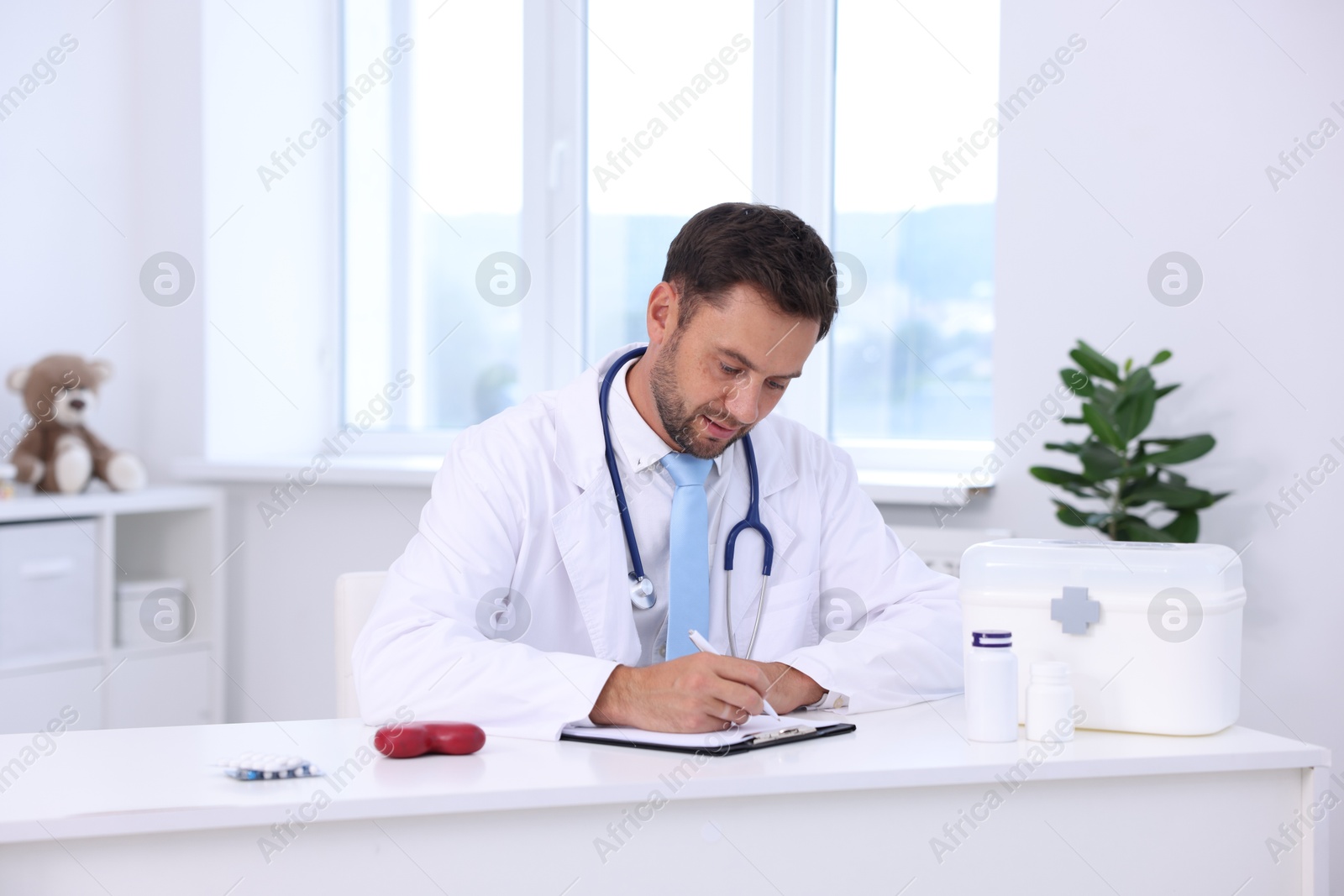 Photo of Professional pediatrician working at desk in hospital