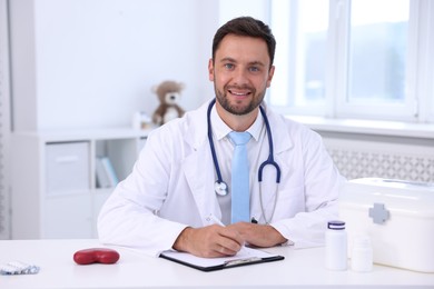 Photo of Professional pediatrician working at desk in hospital