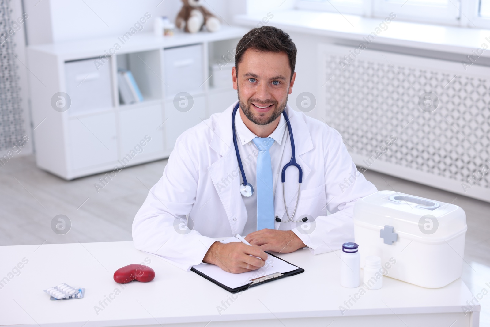 Photo of Professional pediatrician working at desk in hospital