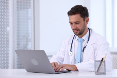 Photo of Pediatrician working on laptop at desk in hospital