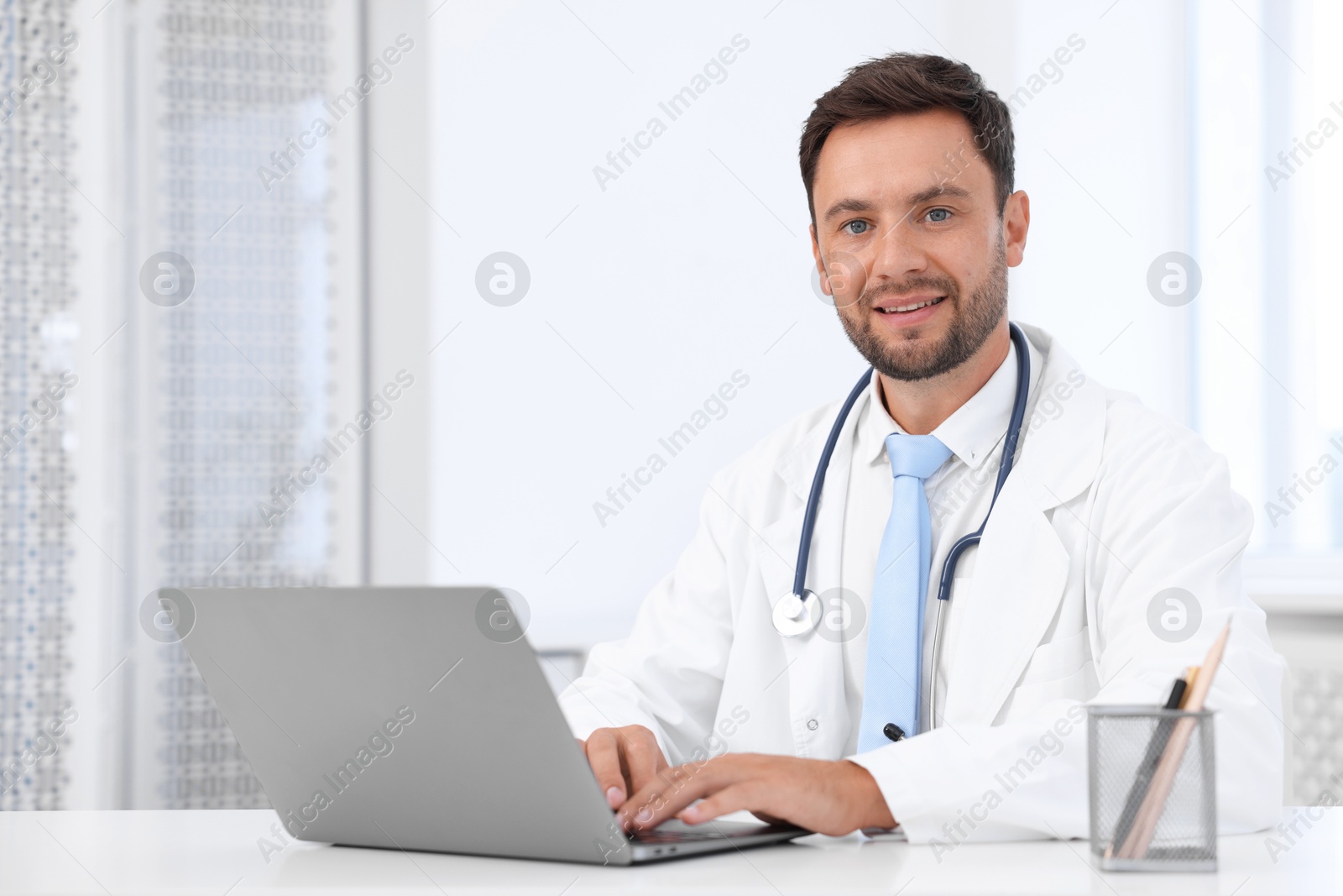 Photo of Pediatrician with laptop at desk in hospital