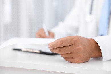 Photo of Pediatrician working at desk in hospital, closeup