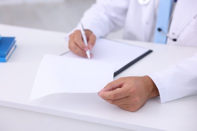 Photo of Pediatrician working at desk in hospital, closeup