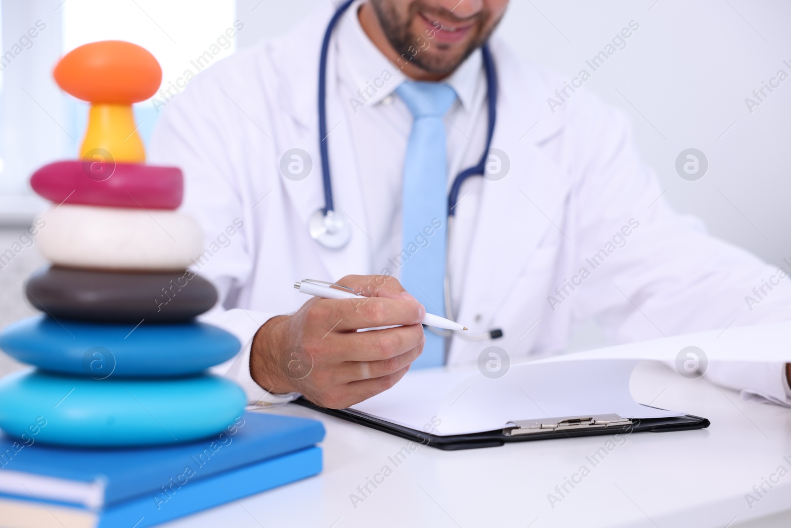 Photo of Pediatrician working at desk in hospital, closeup