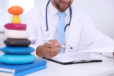 Photo of Pediatrician working at desk in hospital, closeup