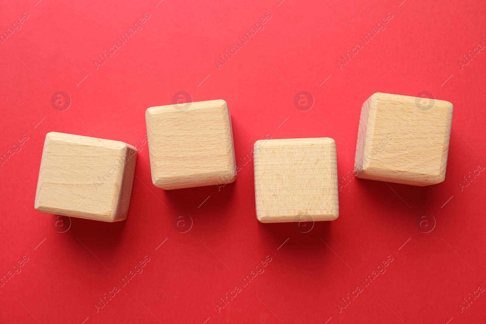 Photo of Blank wooden cubes on red background, flat lay
