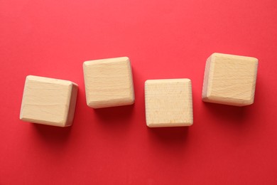 Photo of Blank wooden cubes on red background, flat lay