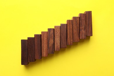 Photo of Wooden blocks on yellow background, flat lay