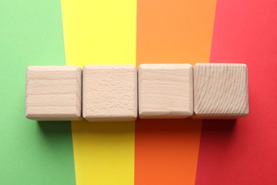 Photo of Blank wooden cubes on color background, flat lay