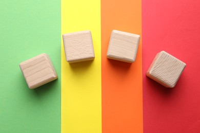 Photo of Blank wooden cubes on color background, flat lay