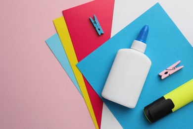 Photo of Glue in bottle, color paper and highlighter on pink background, flat lay. Space for text