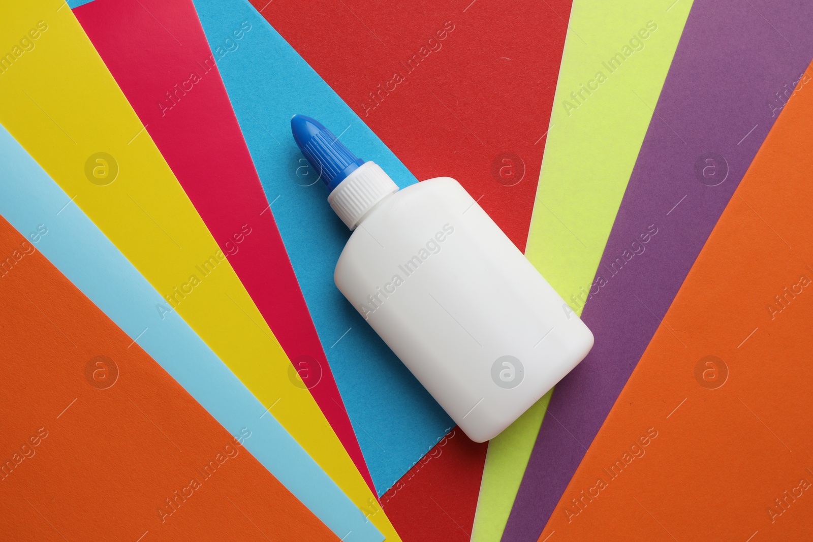 Photo of Glue in bottle on color paper, top view