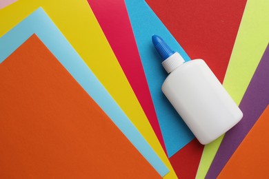 Photo of Glue in bottle on color paper, top view. Space for text