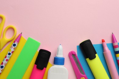 Photo of Glue in bottle, color paper and other stationery on pink background, flat lay. Space for text