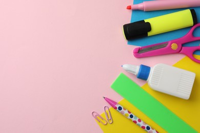 Photo of Glue in bottle, color paper and other stationery on pink background, flat lay. Space for text
