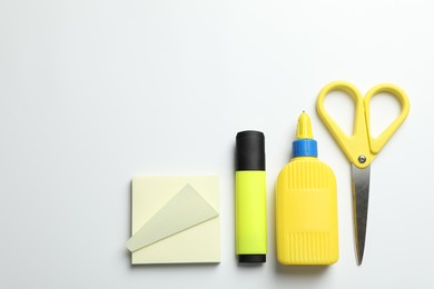 Photo of Glue and other stationery on white background, flat lay. Space for text