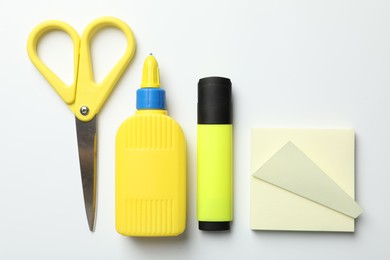 Photo of Glue and other stationery on white background, flat lay