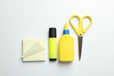 Photo of Glue and other stationery on white background, flat lay